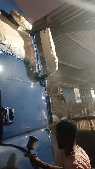 Painter spraying the cab of a blue truck