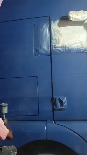Spraying the side and front of a blue truck cab